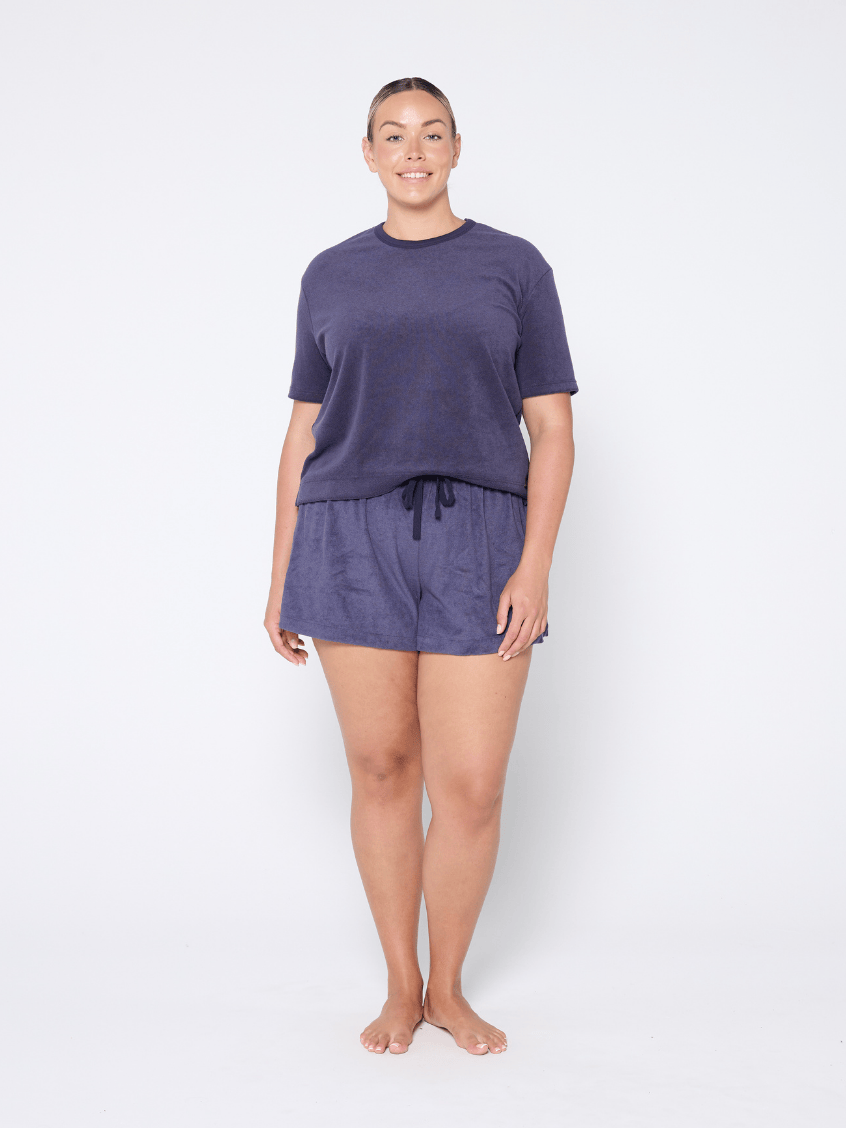 Blonde woman wearing a plus size terry towelling fabric top in navy