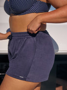 Person wearing navy shorts with a blurred background