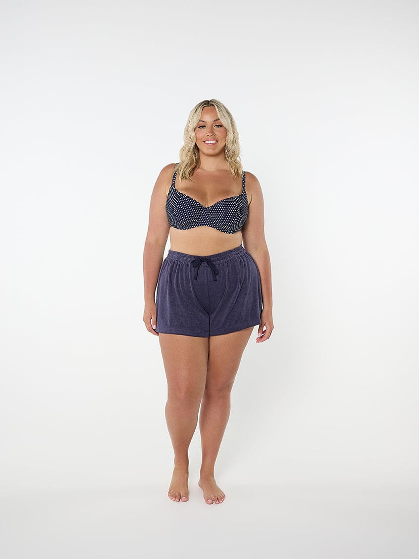 Woman wearing a navy patterned bikini set on a white background