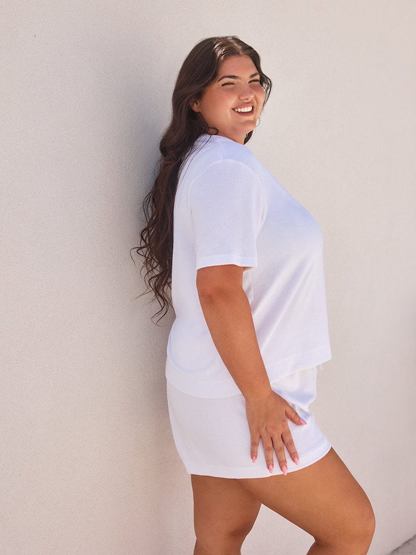 Woman wearing a white t-shirt against a plain background