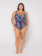 Woman wearing a tiered design tropical leaf patterned swimsuit on a white background