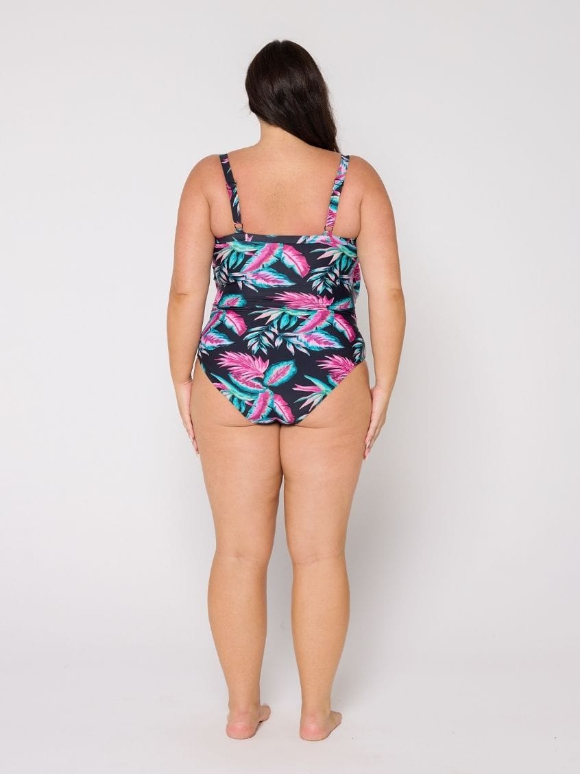 Woman wearing a 3 tier tropical print swimsuit on a white background