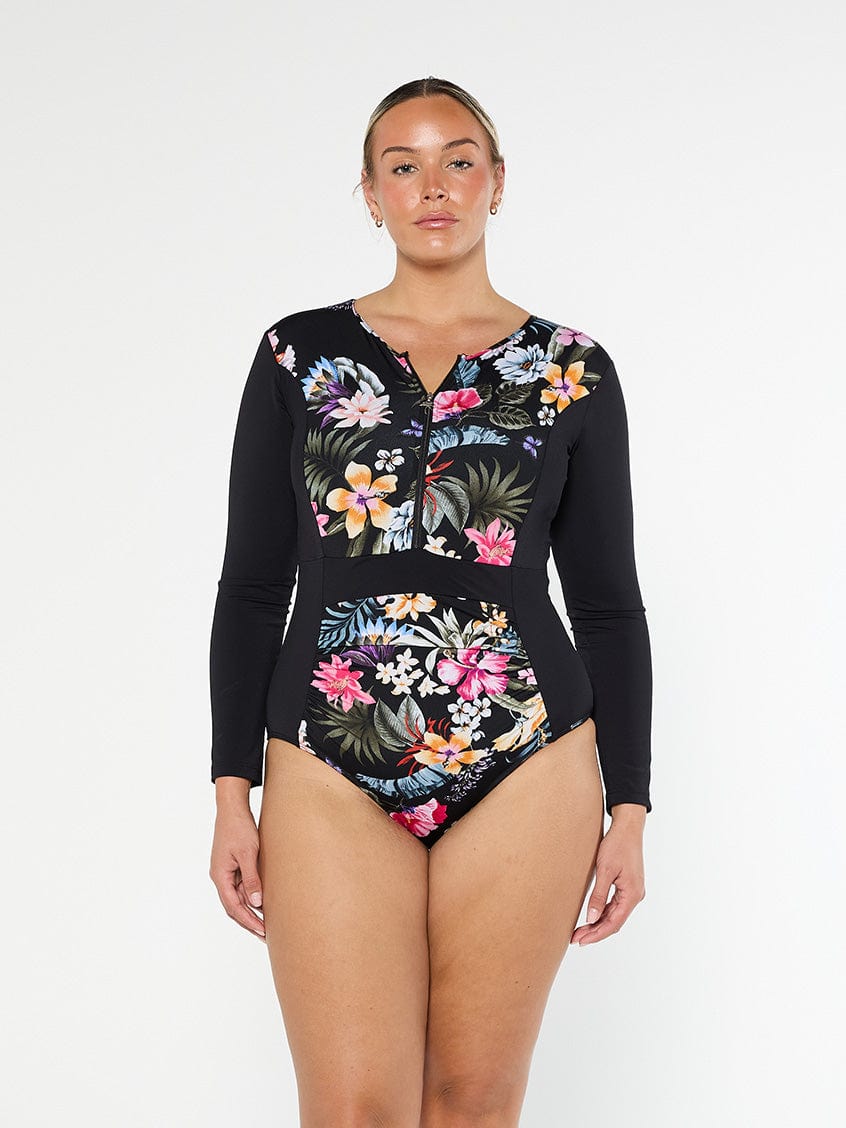 Blonde model showing front of long sleeve one piece in a tropical print