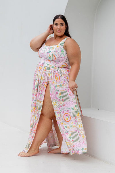 Side profile of plus size model wearing multi coloured maxi skirt with high slit

