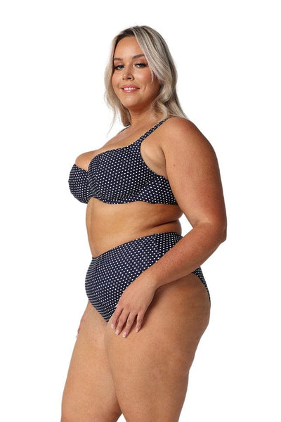 Side profile of model wearing plus size supportive underwire swim top in spotty navy and white