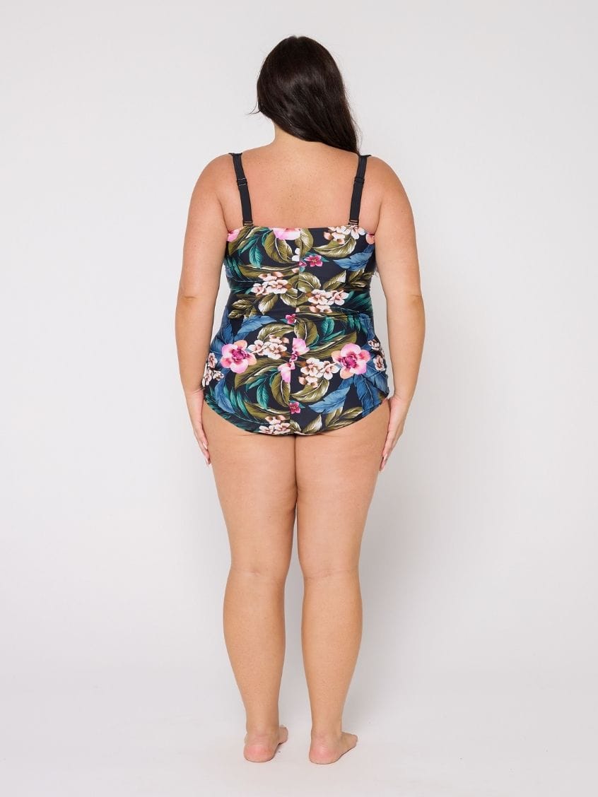Woman wearing a floral swimsuit with adjustable straps against a white background
