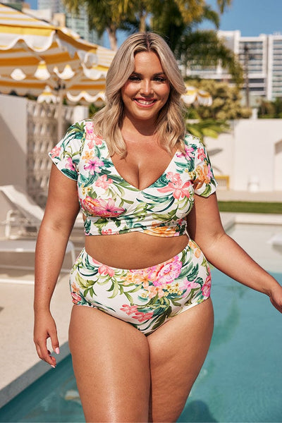 Blonde model wearing white floral wrap bikini top and matching high waisted pant