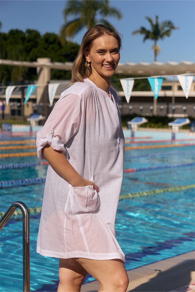 Model wearing white overshirt over swimsuit
