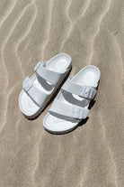 Women's white slide on sandals on beach