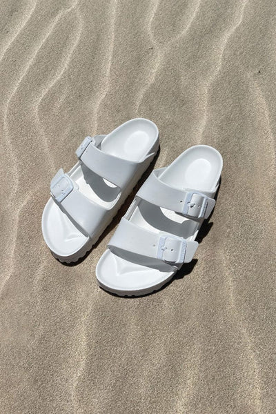 Women's white slide on sandals on beach