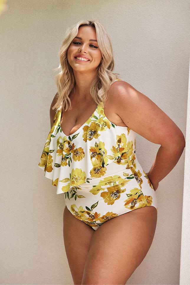 Blonde model wearing yellow floral long frill one piece swimsuit