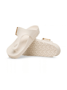 A pair of off-white double-strap slide sandals with textured soles and small gold-tone buckle details, shown on a clean white background.