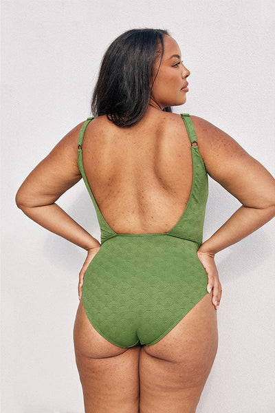 Model showing low back of green textured square neck one piece