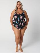 Woman wearing a black floral one-piece swimsuit on a white background