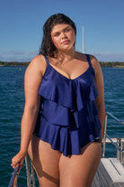 Brunette model by the water wearing three tiered tankini swim top for plus size women