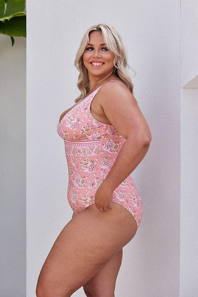 Blonde model showing side of pink floral one piece swimsuit