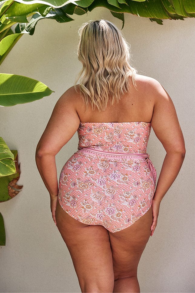 Blonde model showing back of pink strapless one piece with waist tie