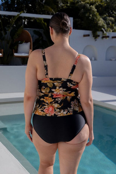 Back of brunette plus size model wearing a floral ruffle swim tankini top for curve women