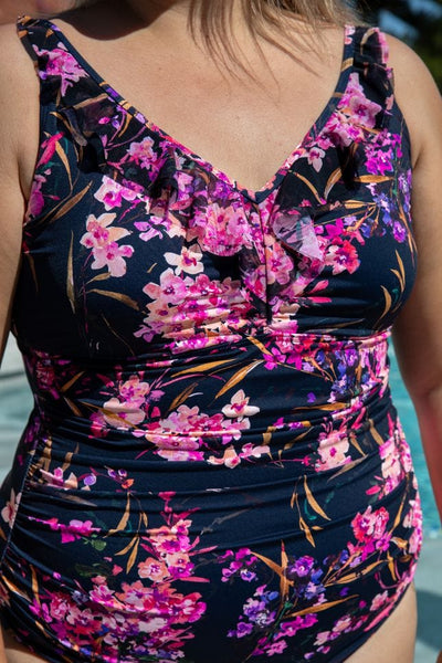 Detail image of model wearing a v neck one piece with mesh detail and underwire in floral print for plus size women