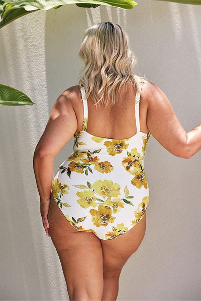 Blonde model showing back of white and yellow floral one piece