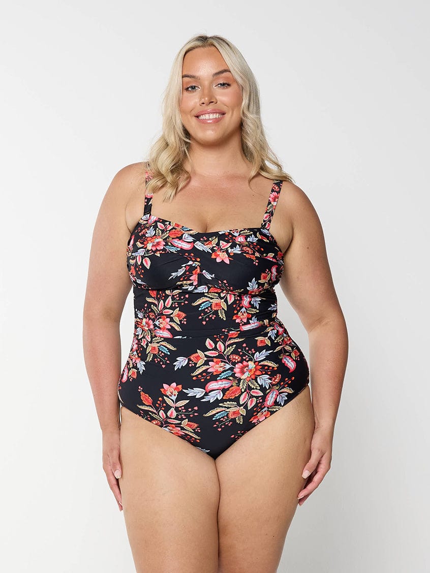 model wearing black and red floral curvy women's one piece