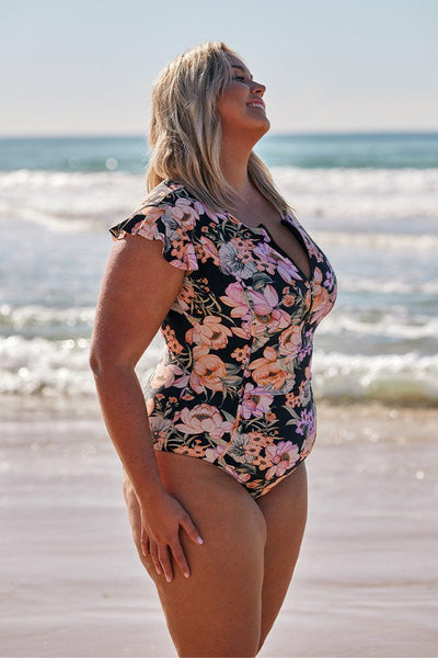 Blonde model wears black and pink floral frill sleeve swimsuit
