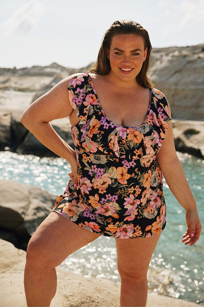 Brunette model wears black floral womens swim dress