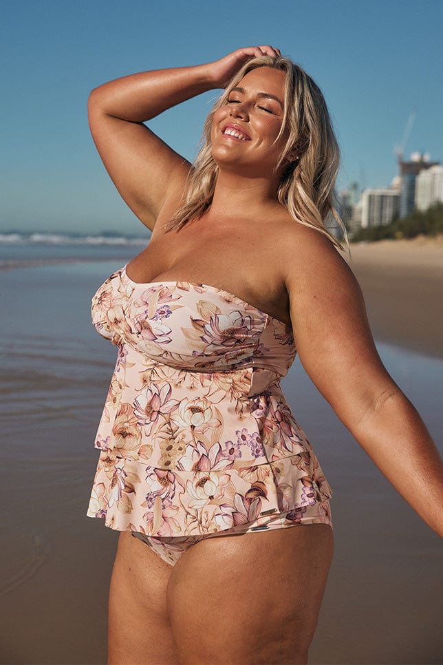 Blonde model wearing light pink strapless swim tankini top