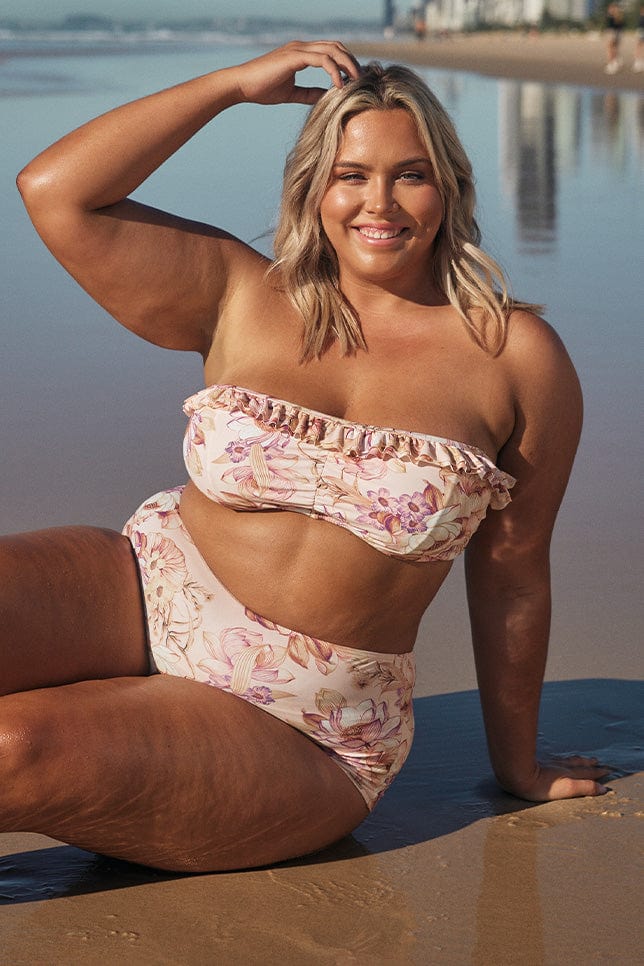 Blonde model wearing light pink floral bikini on beach