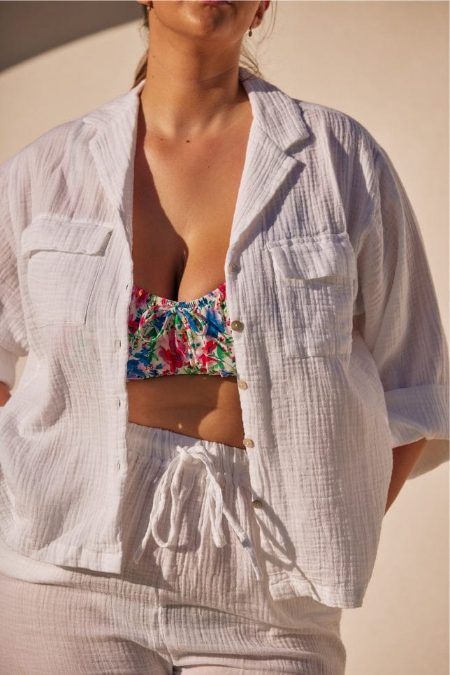 close up photo of a white cheesecloth button through shirt 