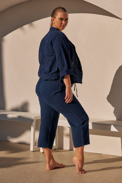 side profile of a blonde model wearing a navy long sleeve and mid calf crepe lounge set