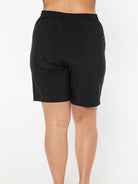 model wearing plain black board shorts