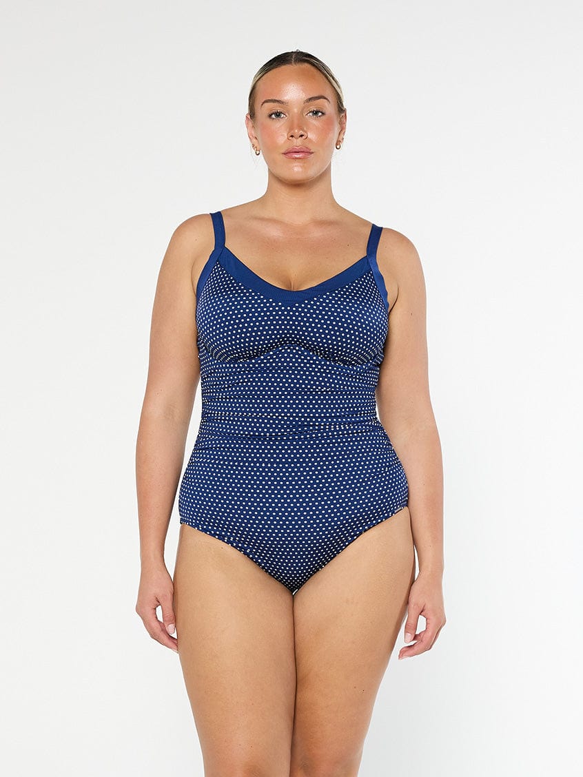 model wearing navy and white dots underwire one piece