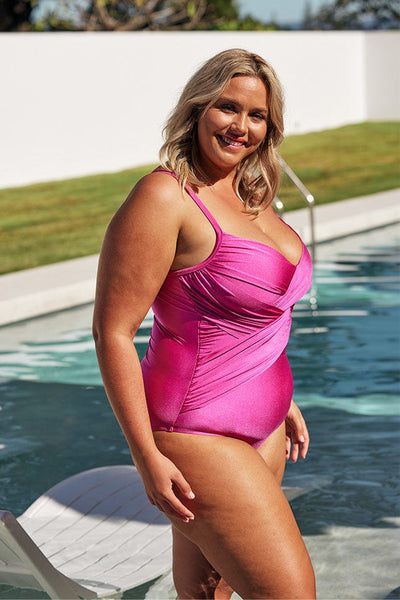 Blonde model wears shiny pink one piece womens swimsuit