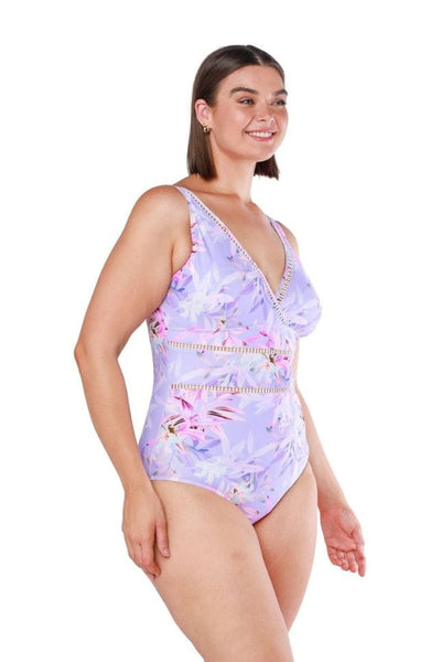 Brunette model wears curvy v neck plus size one piece in lilac floral