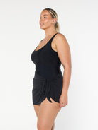 model showing side of black short sarong skirt