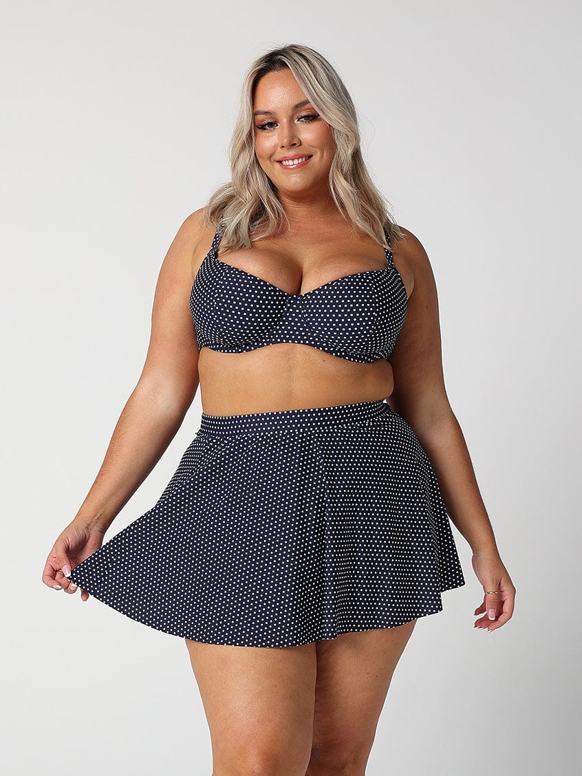 model wearing navy polka dot skater skirt
