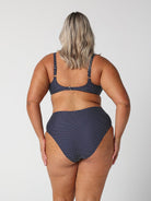 model showing cheeky cut navy polka dot swim bottoms