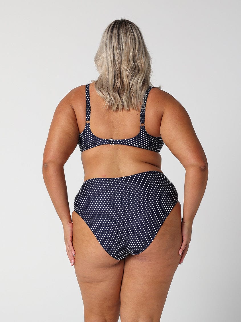 model showing cheeky cut navy polka dot swim bottoms