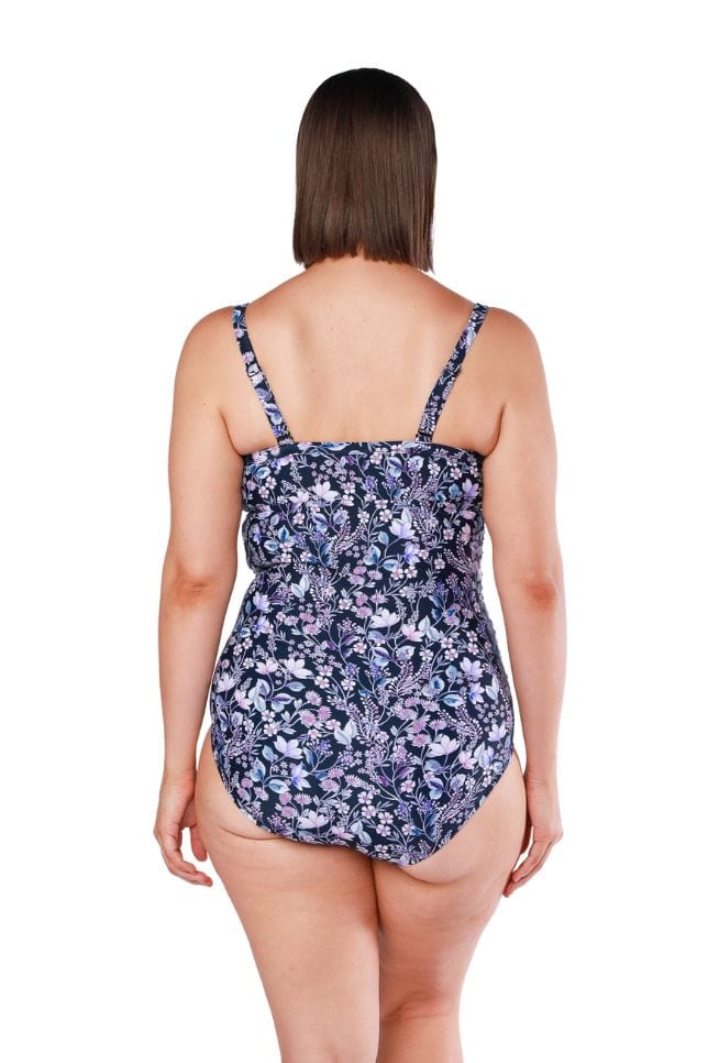 Back of model wearing ruched neckline one piece with adjustable straps in navy floral print for curvy women