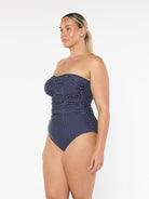 model showing side of navy and white dots bandeau one piece