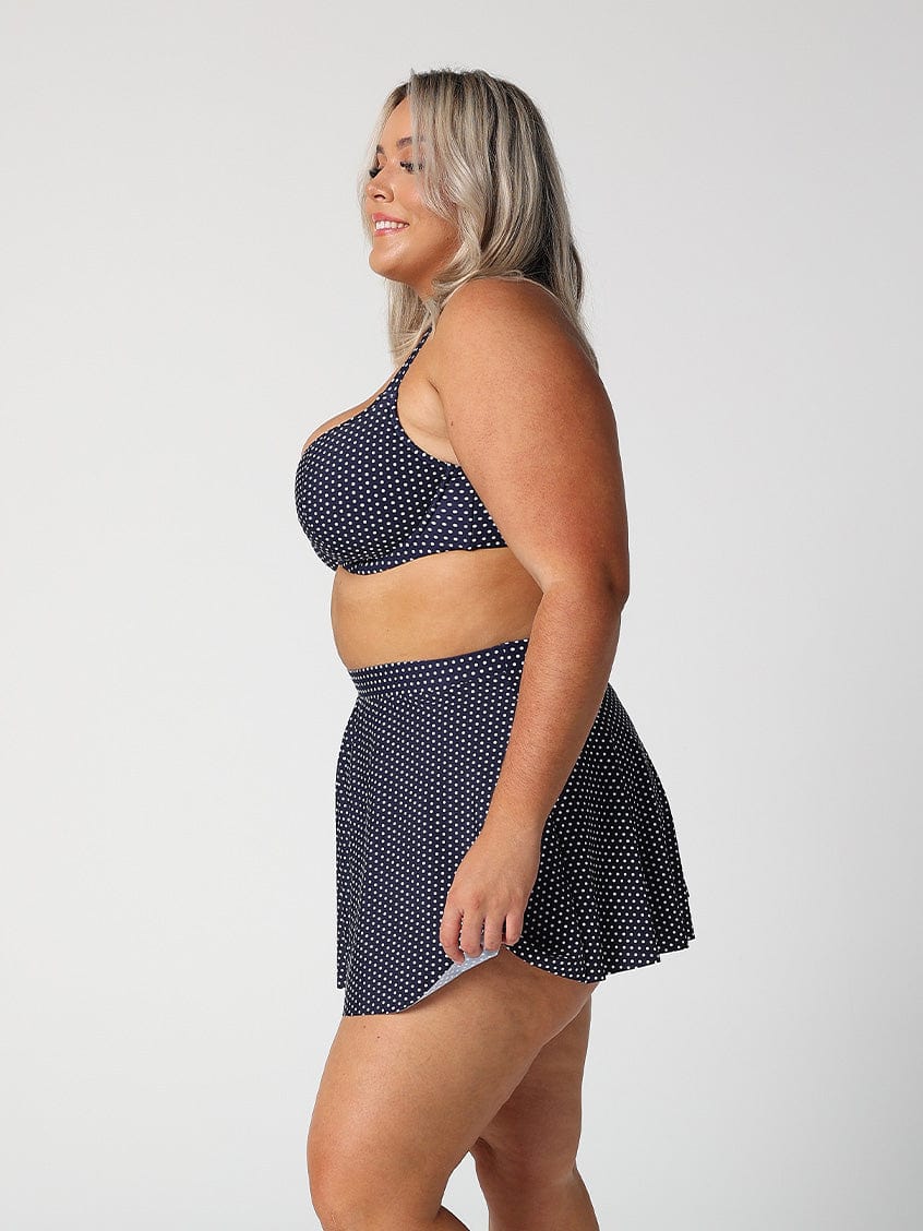 model showing side of navy and white dots skater skirt