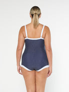 model showing back of navy dots boyleg one piece