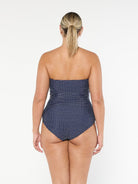 model showing back of navy and white dots strapless one piece