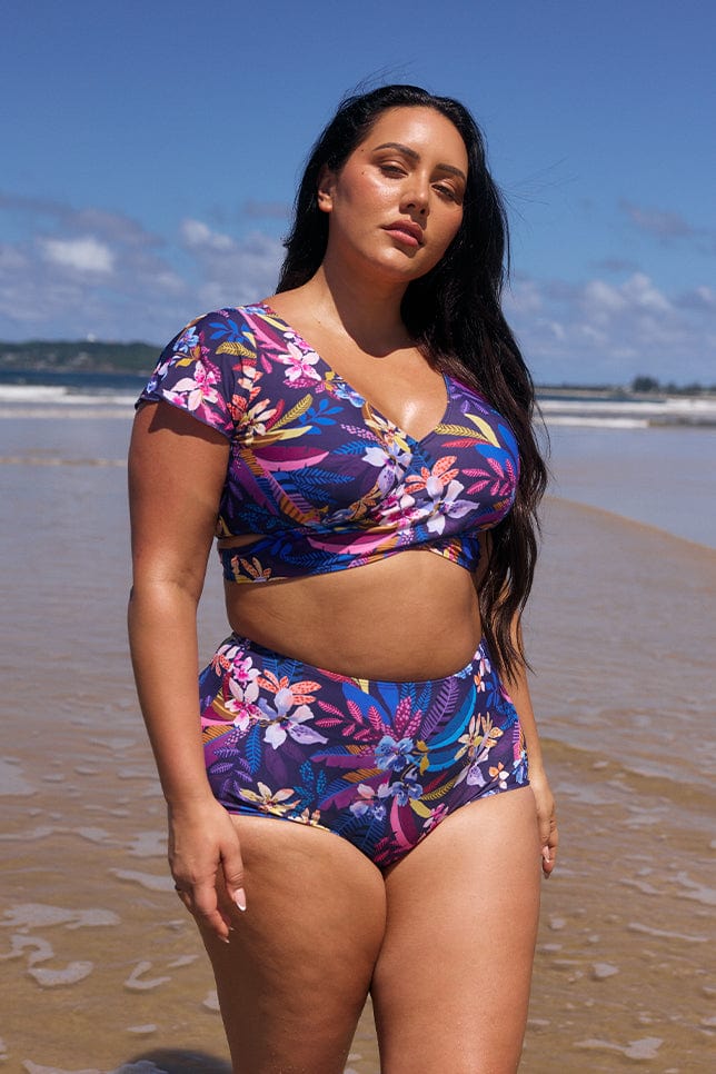 Brunette women on beach wearing wrap one piece bikini top for curve women