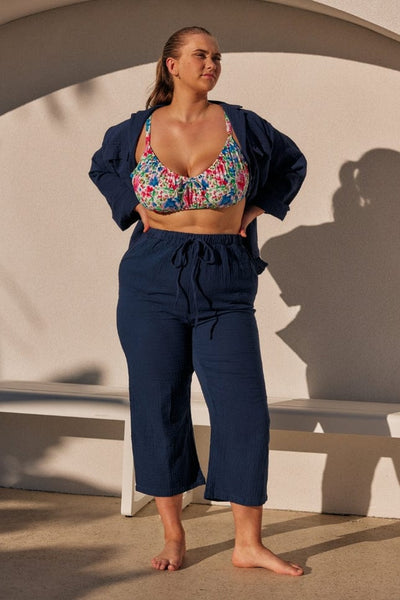 blonde model wearing a navy crepe long sleeve set unbuttoned with a bikini top in floral