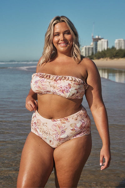 Blonde model wearing light pink high waisted swim pants on beach