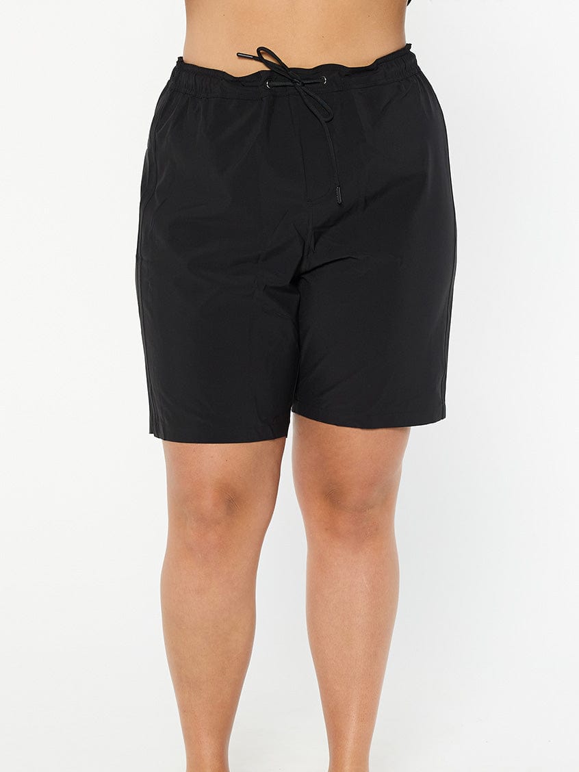 model wearing plain black board shorts