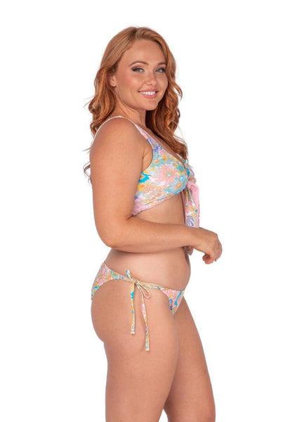 Side of plus size model wearing reversible pink and multi coloured floral tie front bikini top Australia
