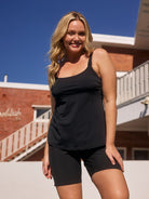 model standing in front of a pool wearing a black above knee boardshort with tie front detail
